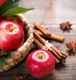 Basket of red apples with cinnamon sticks