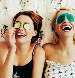 Two women laughing together with eye masks on