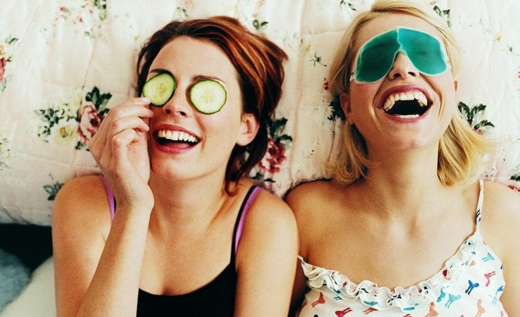Two women laughing together with eye masks on